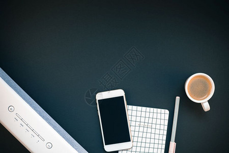平坦的女办公桌工作空间的顶端视野平板白色立体蓝牙音屏和智能手机用于音乐监听和咖啡杯黑背景模板上有复制空间供博客社交媒体使用条形音图片