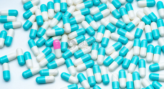 粉红白胶囊药片在蓝人群中非常突出独特和的概念是制药业剂学店概念抗生素药白色的医院药理图片