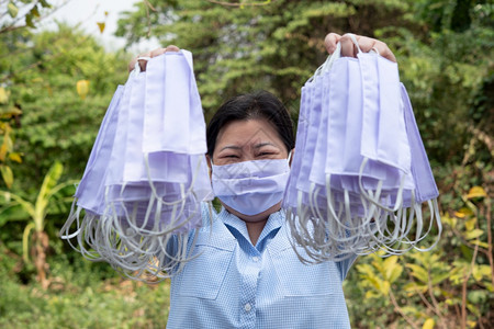 手拿防护口罩的女性图片