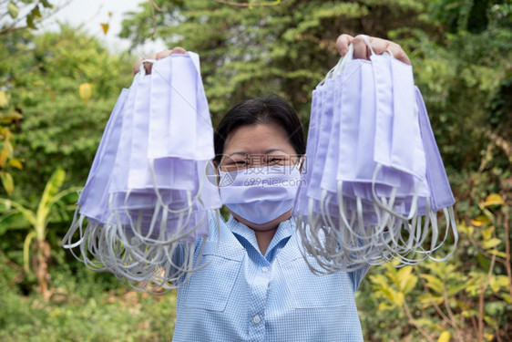 手拿防护口罩的女性图片