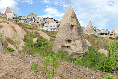在现代建筑和蓝云天空的背景下卡帕多西亚山脉的住宅锥洞穴建起卡帕多西亚山的住宅洞群圆锥结构Capadocia山家景观乡村的图片