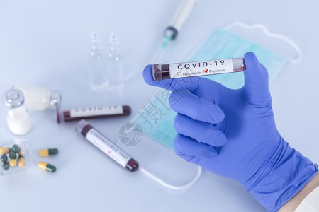 带有防护手套的分析师拿着COVID19冠状测试血液和研究概念专注于测试血液无菌诊断标签图片