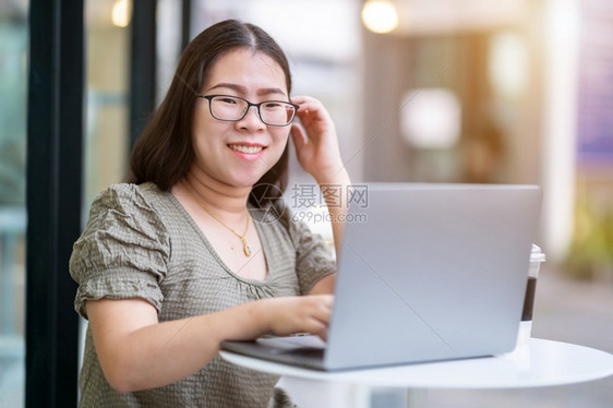 在咖啡店用笔记本电脑咖啡杯和智能手机如背景通信概念等工作的女散校对Portnoyunorg教育快乐的桌子图片