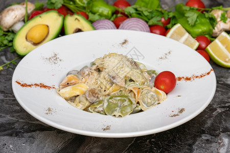 食谱托特利尼和大理石桌上白盘的蔬菜食物子图片