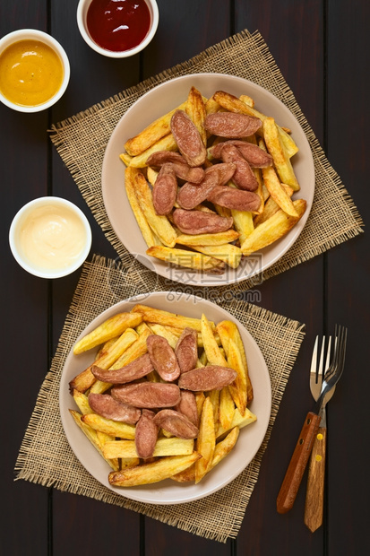 萨尔奇帕斯以薯条和烤香肠南美传统快食制成的Salchipas在餐盘蛋黄酱番茄芥子末和叉上供餐垃圾制作图片