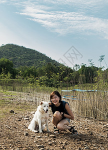 放松娱乐范围一位年轻的白狗女青享受和平的湖边景美其背为宠物和女人休息与享受生活方式无焦点特别是没有重点笑声图片