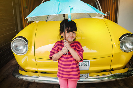 可爱的亚洲人快乐儿童在夏天或雨季保护阳光前带着伞状的快乐孩子肖像34岁的女孩在幸福时刻看着镜头中可爱健康图片