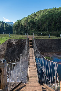 行人小型悬浮桥正在跨越公园水库的洪泛通道上穿越公园中的蓄水池小路景观图片