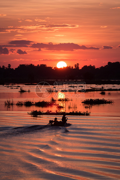 自然抓住在缅甸曼德勒日落时渔民在湖上驾驶一艘渔船的休长轮水图片