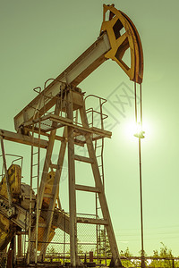 为了桶化石油和天然气行业平台上的油泵钻机操作Pumpjack工业设备油田现场泵正在运行用于发电的摇摆机石油概念调色泵工业设备提取图片