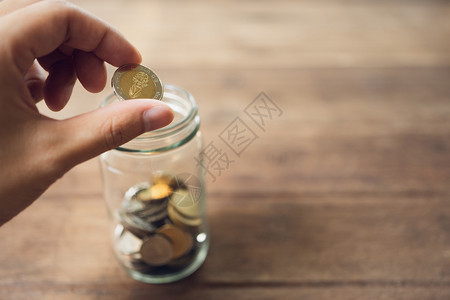 银行业商人把硬币放在玻璃罐里为了省钱在投资上需要的时候花钱并在未来使用投资概念储蓄与复制空间利润标签图片