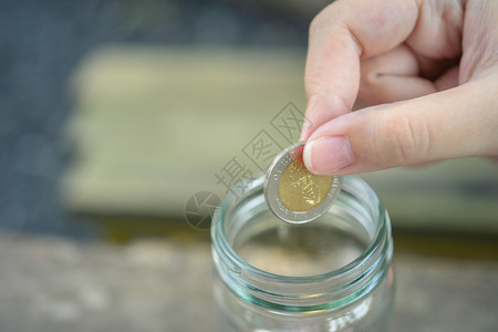 商人把硬币放进玻璃罐里省钱存投资必要时花钱在未来的投资概念中用储蓄和复制空间来节省投资的零用量什么时候标签收入图片