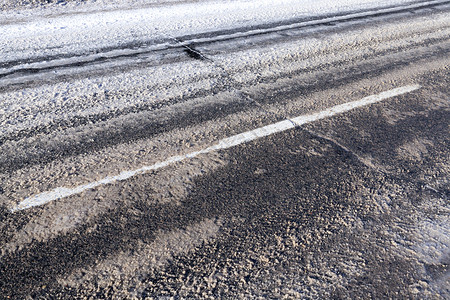 下雪后在路的沥青部分在冬天把白条分隔在木板上框架脚印落下图片