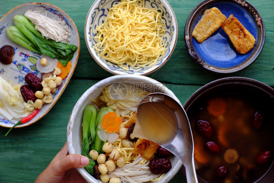 人们用素食越南者自制的面条汤碗用素食品做早餐吃豆腐健康菜果酱水莲花种子奶油巧克力蘑菇香料胡萝卜准备粉末一顿饭图片