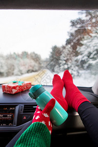 青年放松冬天坐在车里的女孩拿着保温瓶以冬季森林旅行和冬季概念为背景冬天坐在车里女孩拿着保温瓶在冬季森林旅行的背景下和冬天概念年轻图片