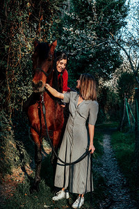 享受自然两个女朋友聊天骑着马乘兜风穿过农村的乡间快感图片