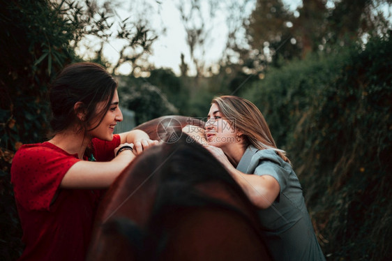 宠物自由两个女朋友聊天骑着马乘兜风穿过农村的乡间快感图片