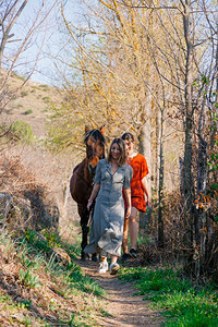 步行阳光享受两个女朋友聊天骑着马乘兜风穿过农村的乡间图片