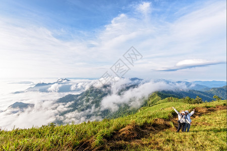 范围远足裙子泰国清莱PhuChiFa森林公园冬季山上云雾的美丽自然景观中两名女游客母亲和儿站在两处挥舞着手在这种美丽的自然景观中图片