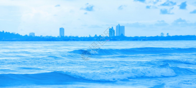 暴风天过后一片宁静的蓝海一个度假镇在背景上模糊不清关注波浪假日度概念全景暴风雨观图片