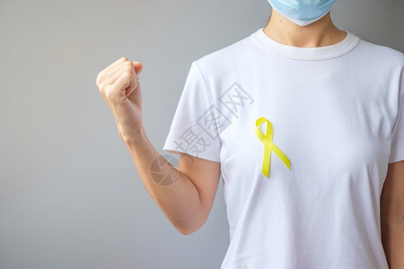 佩戴黄丝带预防癌症概念图片