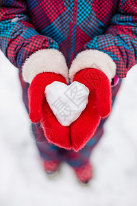 红手套里包着一个雪做成的爱心图片