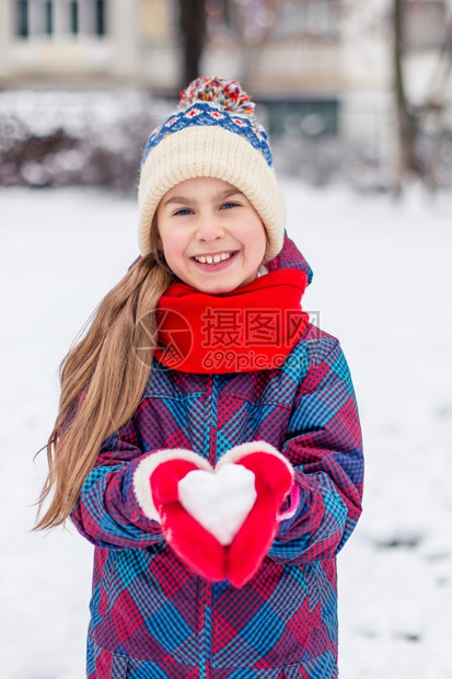 红手套的女孩拿着一颗心型雪球象征着爱华伦天人之情一红手套的女孩拿着心型雪球爱情的象征一种保持孩子图片