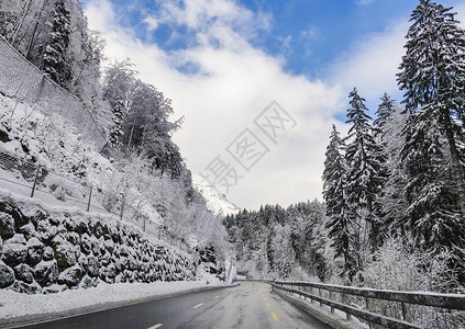 街道白色的美丽冬季景色充满了潮湿滑的公路驾驶状况高山道路四周布满水冰树和雪阳光图片