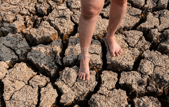 腿天气生态在干旱地区貌景观干旱危机中站立在破裂和干燥土壤上的妇女图片