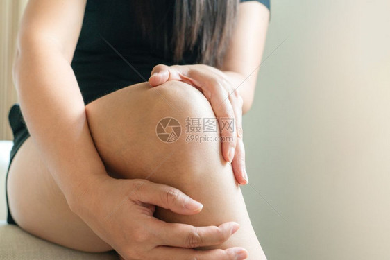 皮肤妇女的膝盖痛触摸家庭内疼痛的膝盖治疗手图片