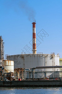 管道河流沿岸工业区石油炼厂的工时场景其中含有蒸汽烟工厂和业污染概念在工作时段结构体蓝色的图片