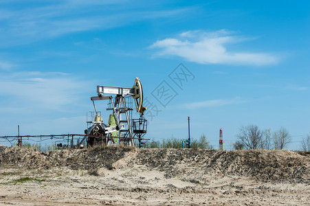 在油田的泵千斤顶夏天蓝背景石油开采概念泵千斤顶石油开采概念抽机勘探钻图片