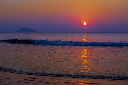 黑暗的颜色乌云天空背景下蛤蜊海的美丽日落热带海滩上的日落自然夏季概念海上的高峰日落与黄光反射在海水上宁静的景水面上地平线发光图片