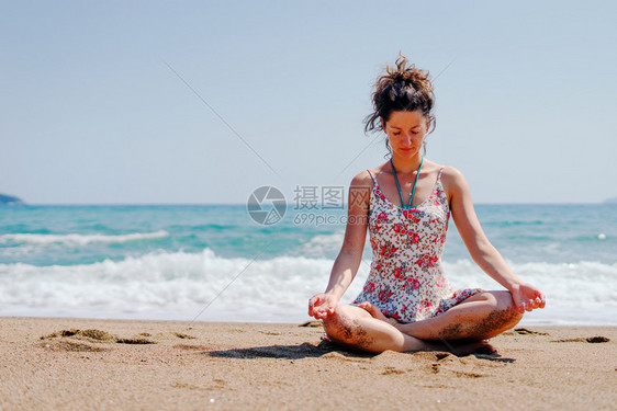 夏服女青年在海边滩或做瑜伽冥想在阳光明媚的白天拉伸冥想放松莲花的位置合十礼正念体式图片