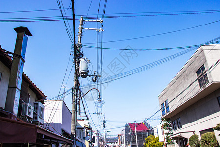 金属丝高的街道上带电线和的杆户外灯具有组织地铺设线路在日本明天背景之下是整洁的图片