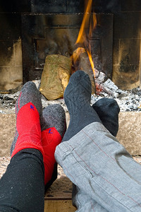 壁炉两只徒步者的脚在冬天长途跋涉之后被火烧热起来温暖的黄色图片