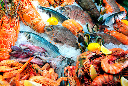 市场新鲜的装有龙虾鳄鱼类蓝克拉布大虾壳类和含柠檬植物片块的Calamari海面食品盒一顿饭图片