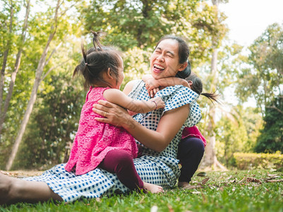 天童年喜悦亚洲母亲和女儿们一起在公园的草地上玩耍如此幸福快乐图片