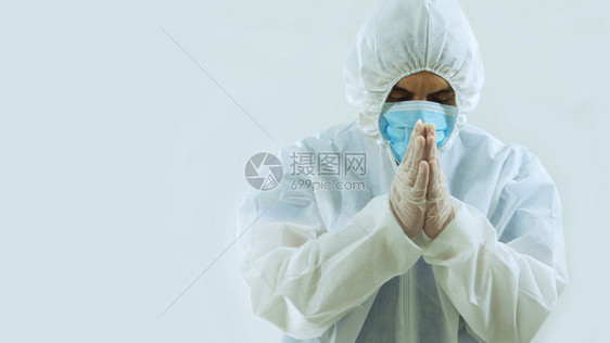 斜手套带蓝色面罩和生物防护服的医前视图头朝下双手闭眼白色背景下祈祷或冥想的态度在白色背景上冥想考试图片