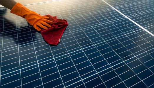 商业建造在屋顶太阳能电池板或光伏模块维护上用清洁太阳能板的人清洁太阳能板可持续源和再生用于绿色概念未来能源利用太阳技术的应用为绿图片