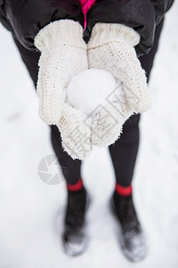 年轻女子手里拿着天然柔软的白雪做球冬天在森林里户外年轻女子手里拿着天然柔软的白雪做球户外保持美丽的乐趣图片