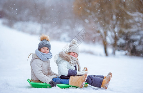 骑术冷冻活动可爱的小女孩享受雪橇滑孩子们在地游和户外玩戏在圣诞节前夕家庭渡假圣诞晚夜露户外可喜的小快乐女孩在冬季雪天滑图片