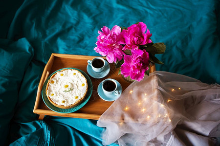 美丽的早晨香草芝士蛋糕咖啡蓝色杯子玻璃花瓶中的粉色牡丹美丽的早晨香草芝士蛋糕玻璃花瓶中的粉色牡丹配件浪漫的女图片