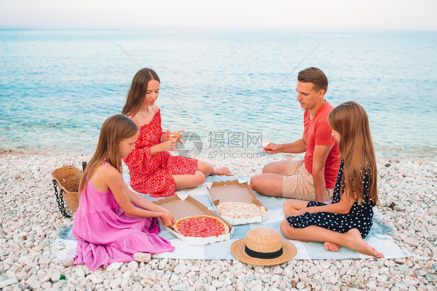 水快乐的家庭带着孩子在海滩上野餐家庭在海滩上野餐岸线女孩图片