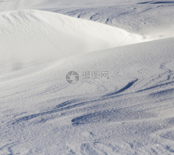 地面光滑的苍白雪表面照亮部分地表在阴影中冬季的雪漂流深移图片