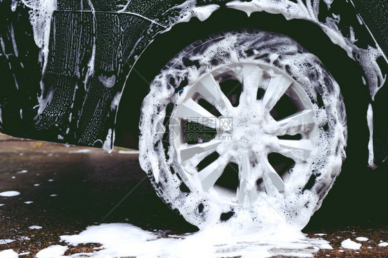 男人利用活泡沫肥皂清洁机轮胎商业清洁服务概念洗车行业打扫图片
