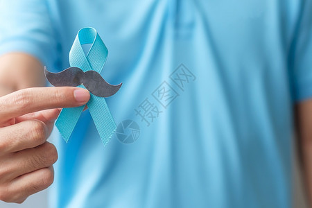 男子手拿着蓝丝带特色预防癌症概念图片