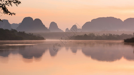 抽象的在日出时一个宁静的夏季湖风波云和日出天空反射在泰国NongTalay背景的湖泊山区和热带森林上苏夫特注重湖面戏剧松弛图片