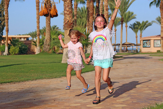 孩子们快乐的幼稚团队在热带度假胜地的小路上奔跑快乐的家庭团队姐妹们享受暑假人家庭假期快乐的幼稚团队在热带度假胜地的小径上奔跑婴儿图片