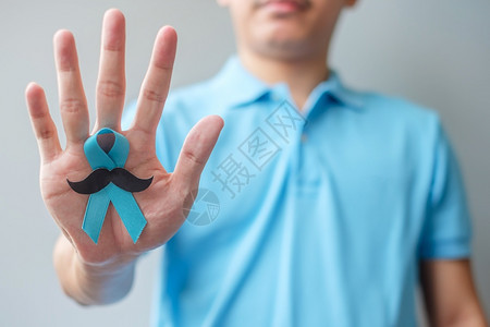 中年男子手拿着蓝丝带预防癌症概念图片